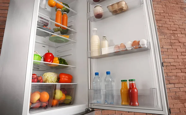 Відкритий холодильник повний різних продуктів харчування — стокове фото