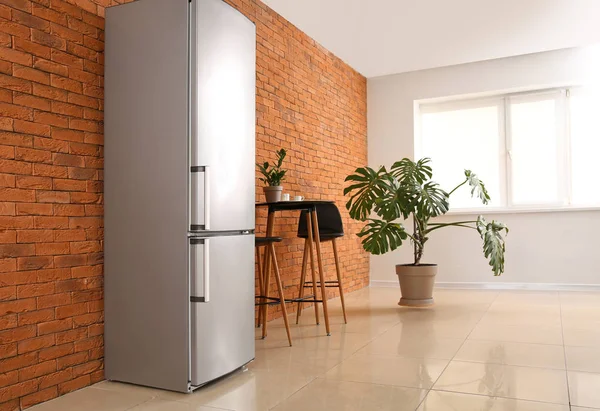 Moderní lednice, stůl a židle v kuchyni — Stock fotografie