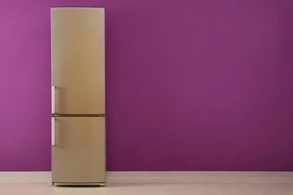 Modern fridge near color wall — Stock Photo, Image