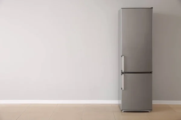 Réfrigérateur moderne près mur blanc — Photo