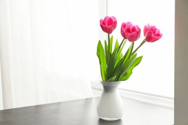 Pencere yakın masada güzel lale çiçekler ile vazo