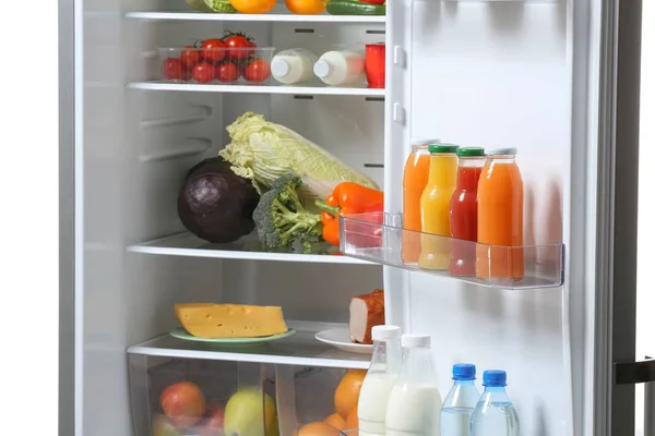 Открытый холодильник с разнообразной едой — стоковое фото