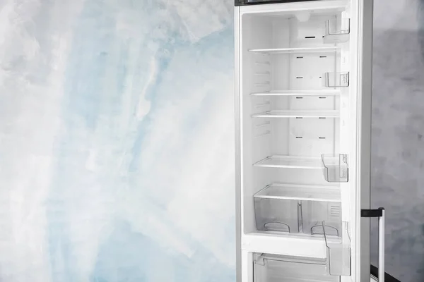 Apri il frigorifero vuoto vicino alla parete luminosa — Foto Stock