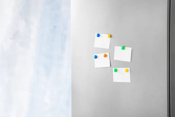 Papers with magnets on fridge door — Stock Photo, Image