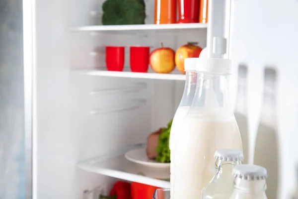 Бутылки молока в открытом холодильнике — стоковое фото