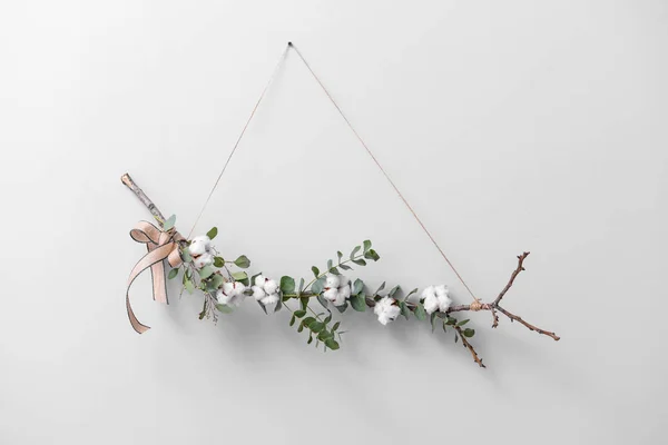 Florale Komposition mit Baumwollblumen, die an einer hellen Wand hängen — Stockfoto