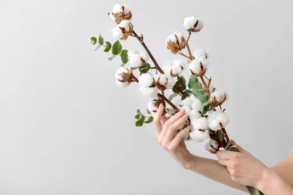 Kvinnliga händer som håller blommig komposition med bomulls blommor på ljus bakgrund — Stockfoto