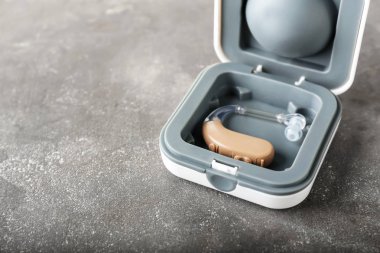 Gri arka planda işitme cihazı ile kutu