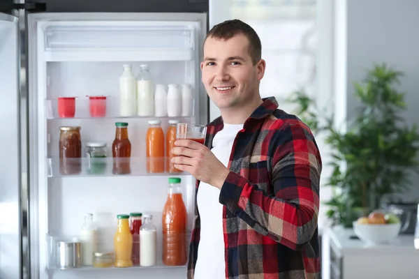 Чоловік стоїть біля відкритого холодильника вдома — стокове фото