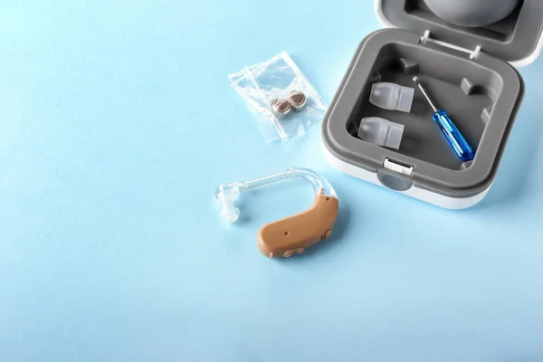 Box s pomůcku pro sluchové pomůcky a doplňky na barevném pozadí — Stock fotografie