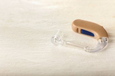 Beyaz ahşap arka planda işitme cihazı