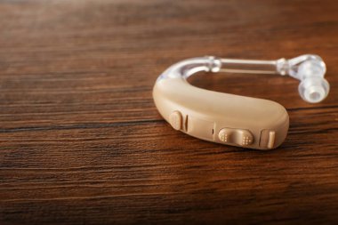 Ahşap arka plan üzerinde işitme cihazı