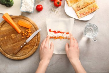 Gri masada lezzetli bahar rulo hazırlanıyor kadın