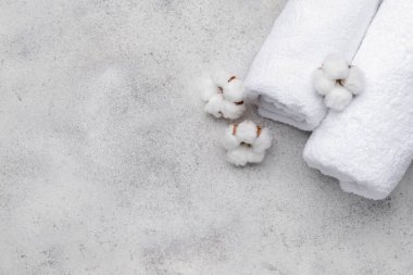 Gri arka planda yumuşak havlularla pamuklu çiçekler