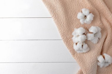 Beyaz masada yumuşak havlu ile pamuk çiçekler