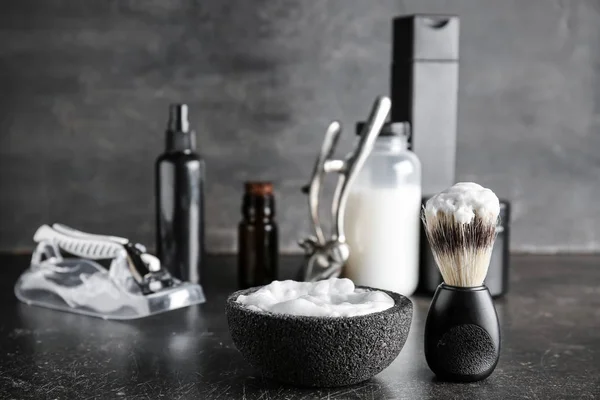 Foam with shaving brush on dark table — Stock Photo, Image