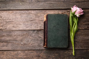 Ahşap arka planda güzel lale ve kitap