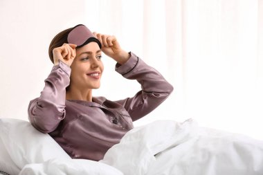 Genç kızla yatakta uyku maskesi