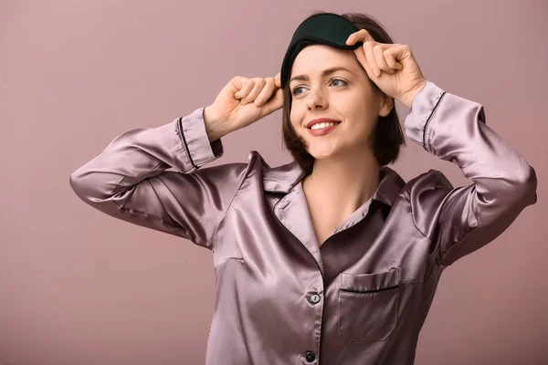 Young woman with sleep mask on color background — Stock Photo, Image