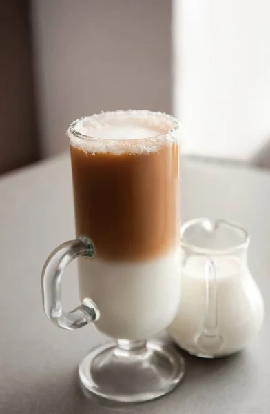 Szklany kubek pysznego kawy frappe i Dzbanek mleka na szarym stole — Zdjęcie stockowe