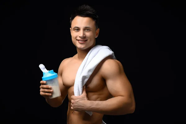 Sportig man med proteinshake på mörk bakgrund — Stockfoto