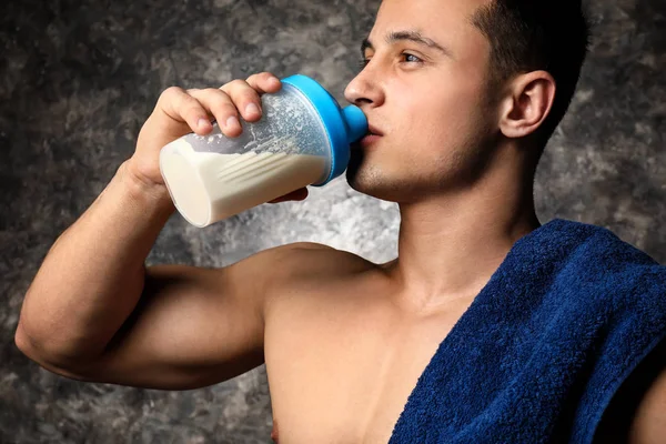 Sportieve man drinken eiwit shake op donkere achtergrond — Stockfoto