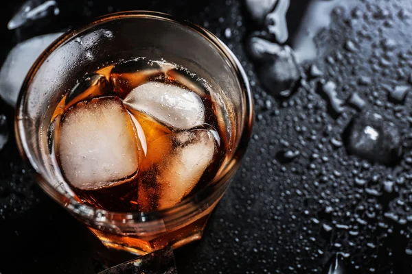 Glass of cold whiskey on dark background — Stock Photo, Image