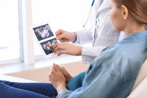 Молодая беременная женщина посещает своего гинеколога в клинике — стоковое фото