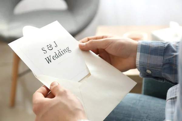 Mężczyzna trzyma kopertę z zaproszeniem na ślub, zbliżenie — Zdjęcie stockowe