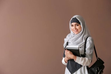 Renkli arka planda kitaplar ile genç Müslüman kadın