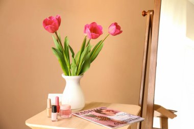 Odada renkli duvar yakın taze çiçekler, moda dergisi ve makyaj kozmetik ile tablo