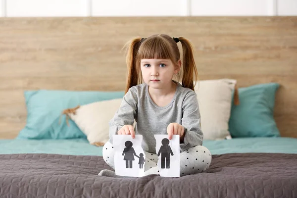 Sad little girl with torn picture of family at home. Concept of divorce — Stock Photo, Image