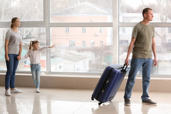 Мужчина с чемоданом покидает семью — стоковое фото