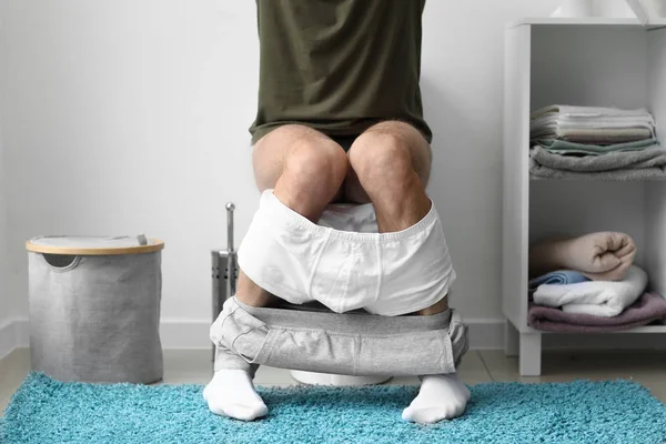 Uomo seduto sulla tazza del water a casa — Foto Stock