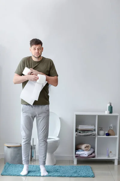 Man with rolls of paper in WC — Stock Photo, Image