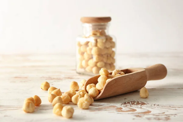 Scoop with tasty hazelnuts on wooden table — Stock Photo, Image