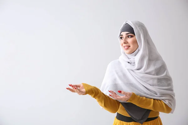 Vacker muslimsk kvinna på ljus bakgrund — Stockfoto