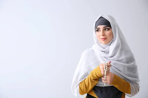 Moslimvrouw met Tasbih op lichte achtergrond — Stockfoto
