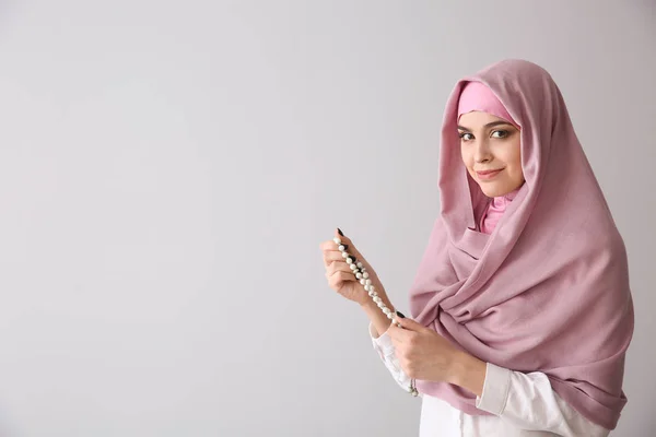 Moslimvrouw met Tasbih op lichte achtergrond — Stockfoto