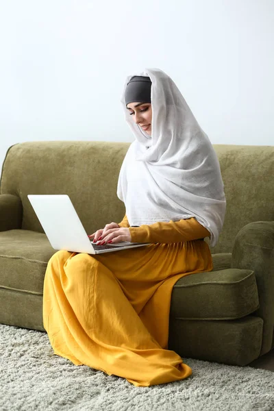 Muslim woman with laptop at home