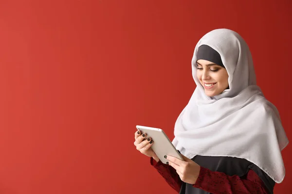 Moslimvrouw met Tablet-computer op kleur achtergrond — Stockfoto