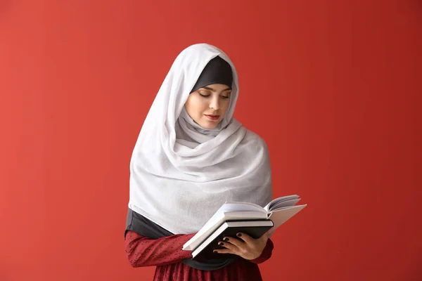 色の背景に本を持つイスラム教徒の女性 — ストック写真