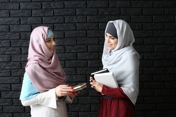 Moslimvrouwen met boeken op donkere achtergrond — Stockfoto