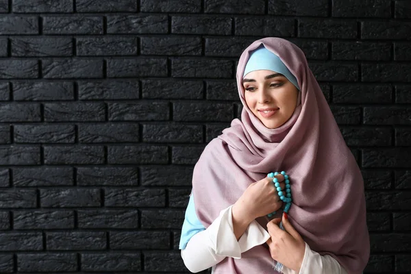 Mulher muçulmana com tasbih no fundo escuro — Fotografia de Stock