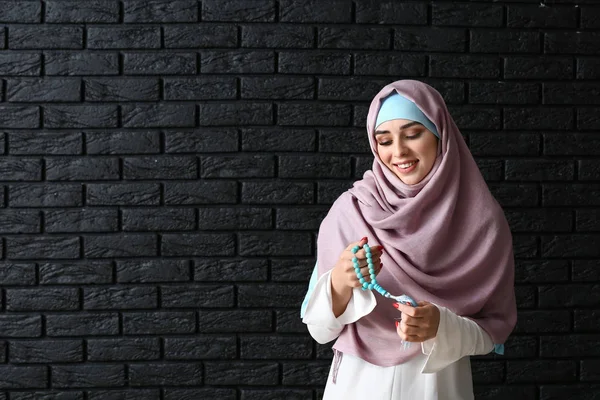 Muslim wanita dengan tasbih di latar belakang gelap — Stok Foto