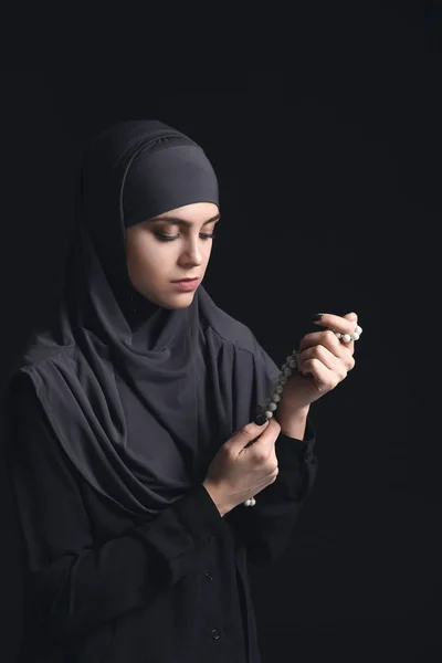 Muslimische Frau mit Tasbih auf dunklem Hintergrund — Stockfoto