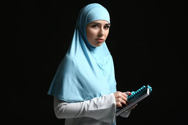 Moslim vrouw met Koran en tasbih op donkere achtergrond — Stockfoto