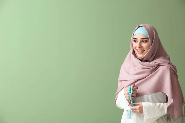 Moslimvrouw met Tasbih op kleur achtergrond — Stockfoto