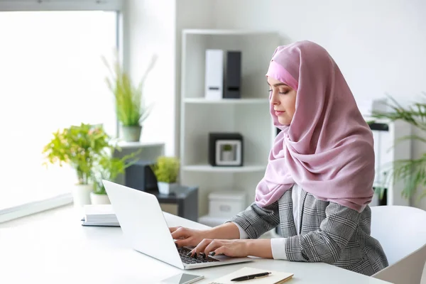 Muslimsk kvinna som arbetar på laptop på kontoret — Stockfoto