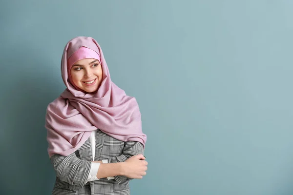 Vacker muslimsk kvinna på färg bakgrund — Stockfoto